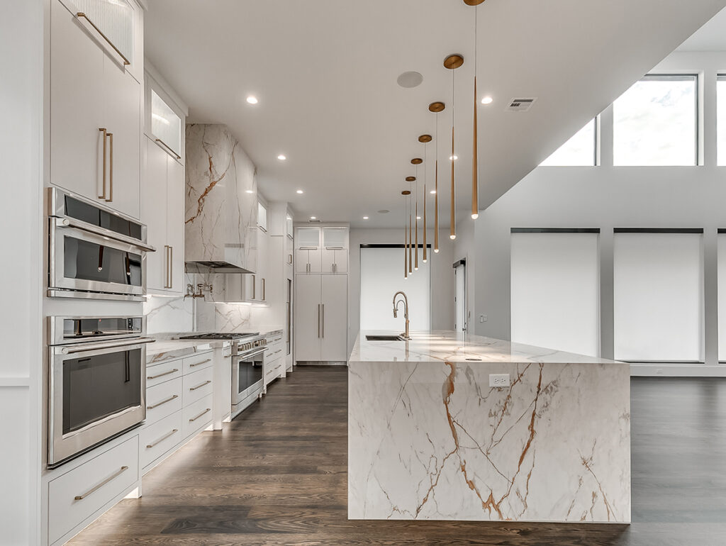 Luxury kitchen design in a modern transitional home with marble island and brass fixtures