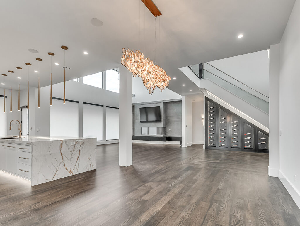 Open-concept living space in a modern transitional home with marble island and wine wall