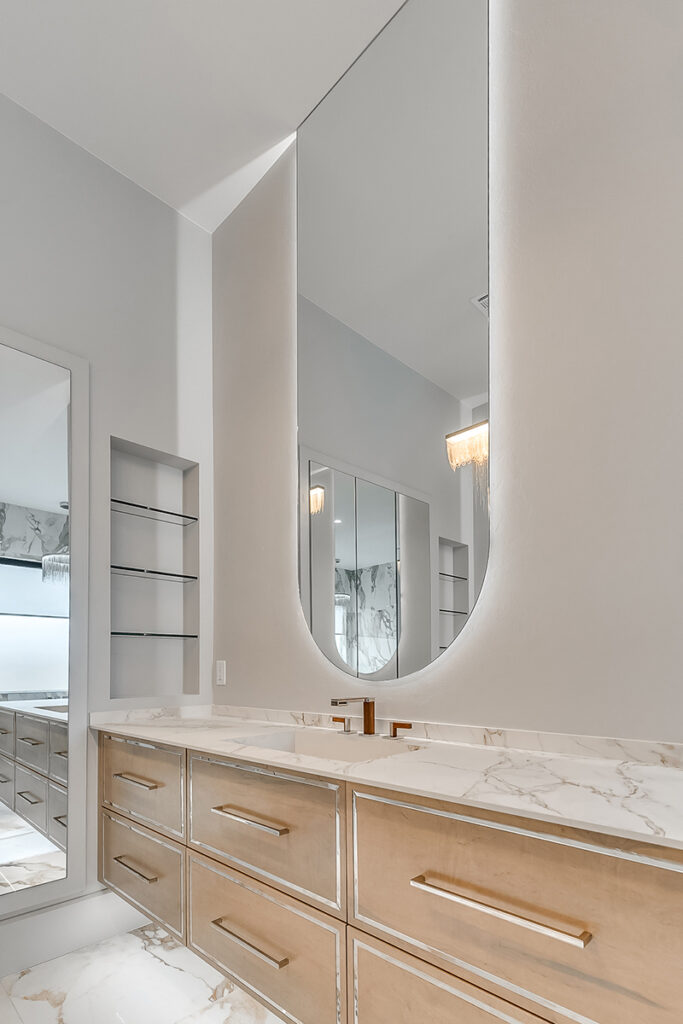Elegant vanity in a traditional home bathroom with marble surfaces and warm wood cabinetry