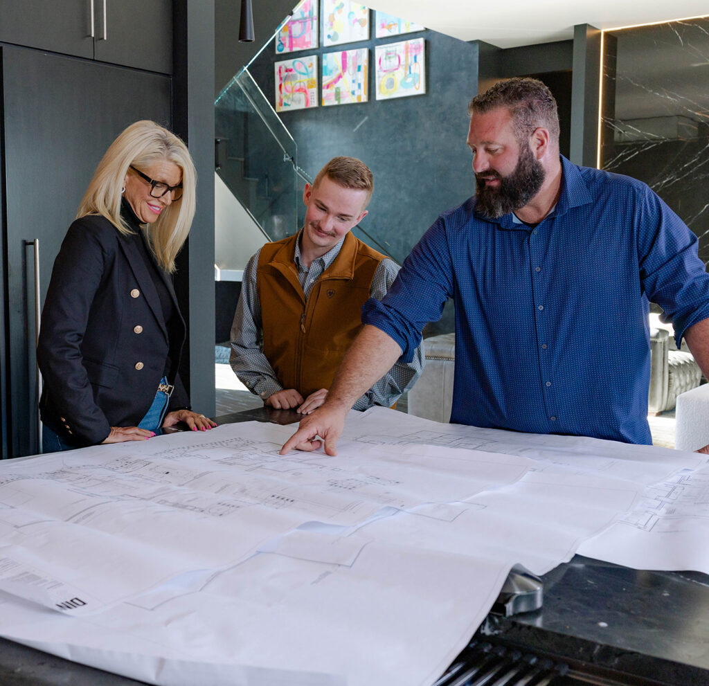 A team collaborates over home blueprints, planning the home-building process.